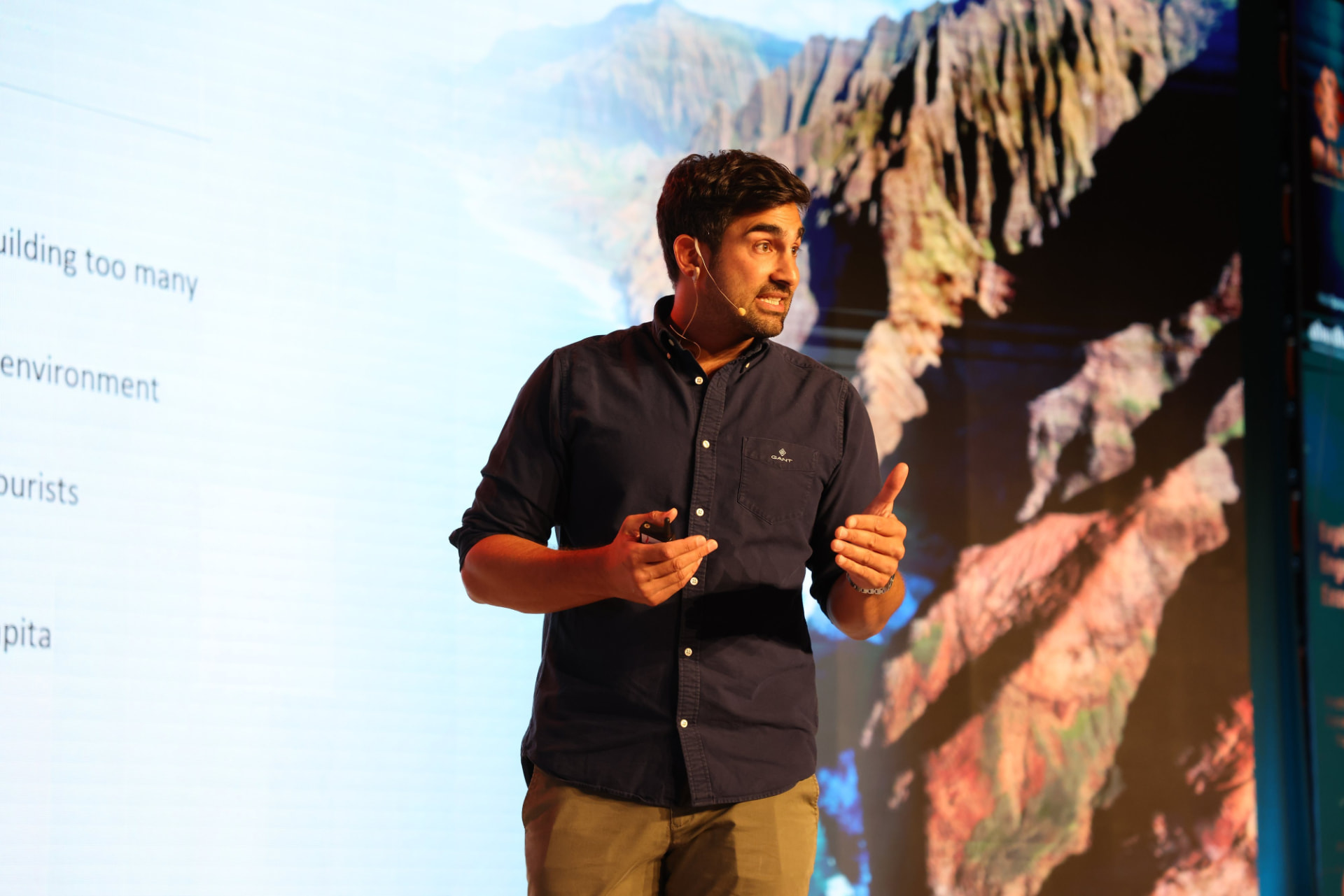Paris Norriss speaking on stage with a mountain landscape behind him